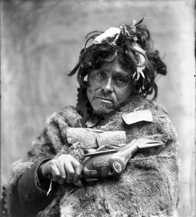 Shaman fra tlingit-folket med ravne-rasle i hånden, ca. 1896-1913 (ukendt fotograf)